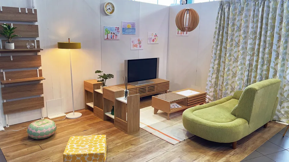 緑のソファとブラウン系の家具でまとめられた温かみのある部屋