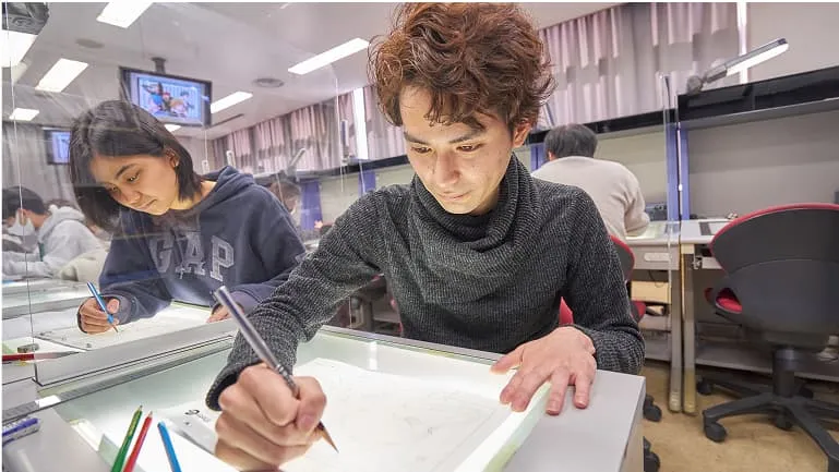 学生が場面設定を描いている様子