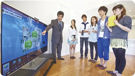 学生たちが画面を見ながら講師に教わっている様子