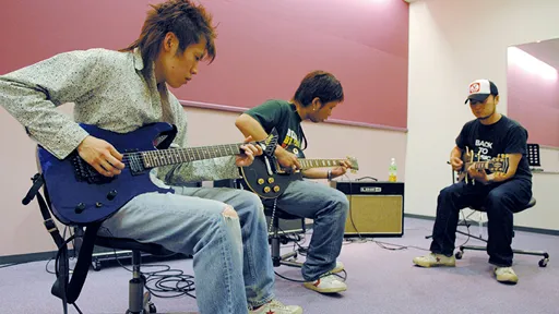 学生たちがエレキギターのレッスンをする様子