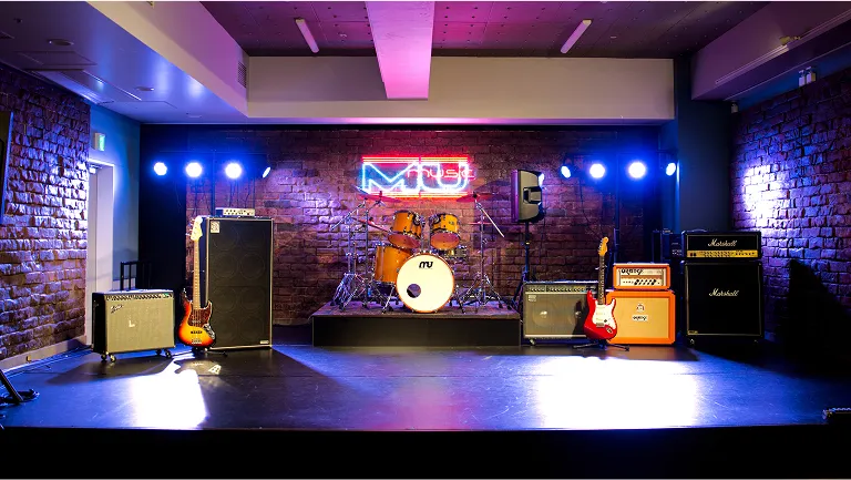 音響機器が完備され照明やネオンサインに照らされたステージ