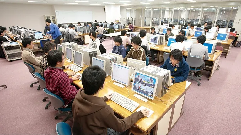 沢山のパソコンが並んだゲーム制作スタジオで作業をしている学生たち