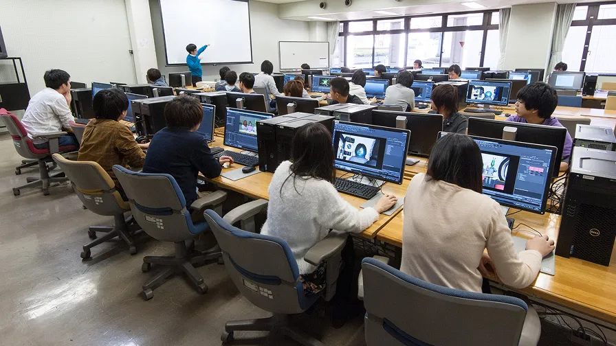 ゲーム制作スタジオで学生たちがパソコン作業をしている様子