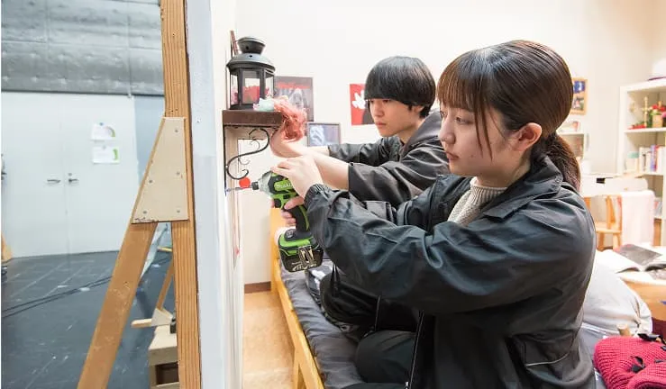 学生たちが壁に装飾を取り付けている様子