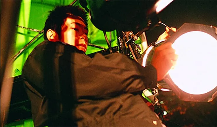 屋外で照明機材を操作している学生