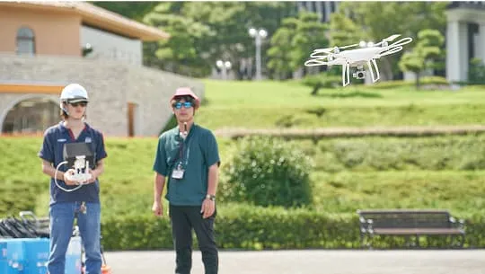 学生が屋外でドローンを操作している様子