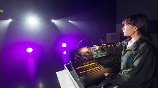 学生がプロ仕様の機材で照明操作をしている様子