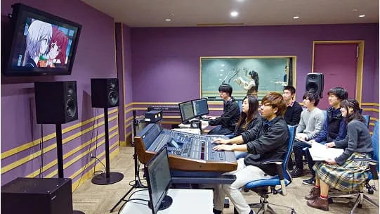 モニターの映像を見る学生たちと奥の部屋でアフレコ作業をしている学生の様子