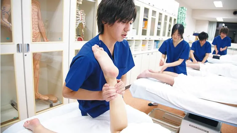 学生が脚の指圧をしている様子