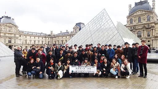 建築物の前で撮影された大勢の学生たちの集合写真