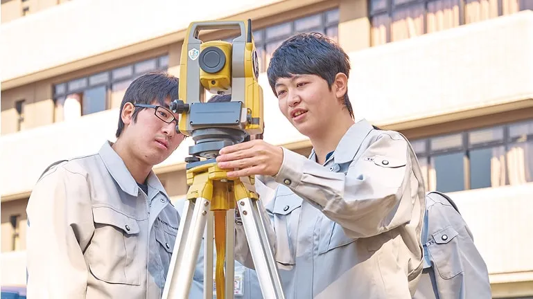 二人の学生が測量の実習をしている様子