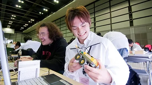 学生たちが笑顔でロボット製作をしている様子