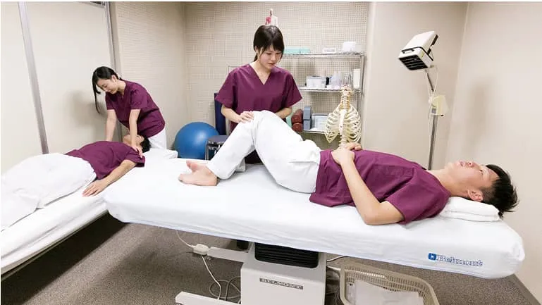 スポーツ鍼灸コンディショニング・ルームで身体の指圧をしている学生たち