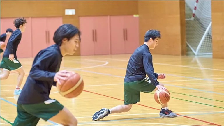 低い姿勢でのドリブルを練習する生徒たち