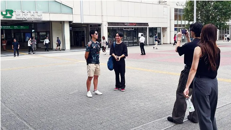 駅前で記念撮影をする生徒たち