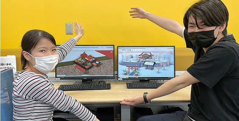 2名の学生がPCの画面を見せている様子