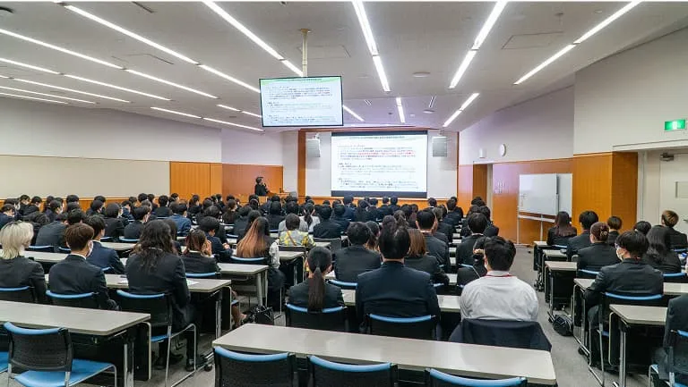 大勢の学生がスクリーンを見ながら受講する様子