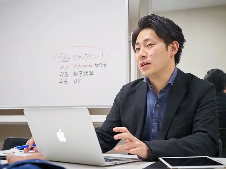 正面を向いて話す企業の担当者