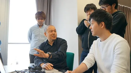 先生と学生たちが話し合いをしている様子