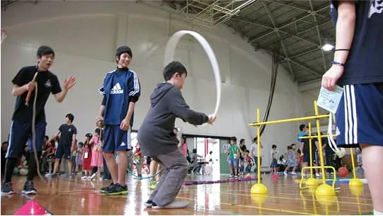 縄跳びをする子供とそれを見守り応援する生徒たち