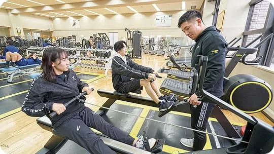 広い環境でマシンを使ってそれぞれのトレーニングをする生徒たち