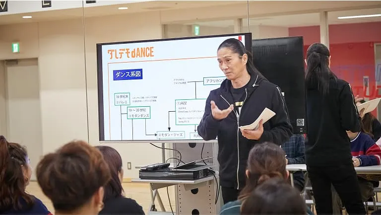 スクリーンに映し出された図を見せながら話す講師