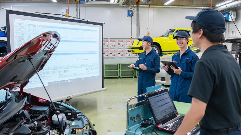 学生たちが自動車の電子制御実習を行っている様子