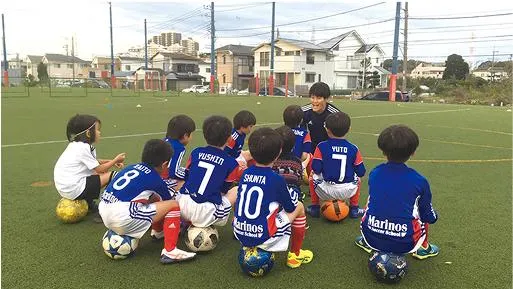 子供たちにサッカーを指導するインターン中の生徒