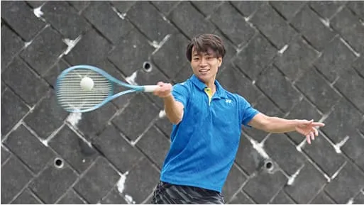 学生がラケットでボールを打ち返している様子