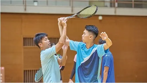 学生が講師から構えを教わっている様子