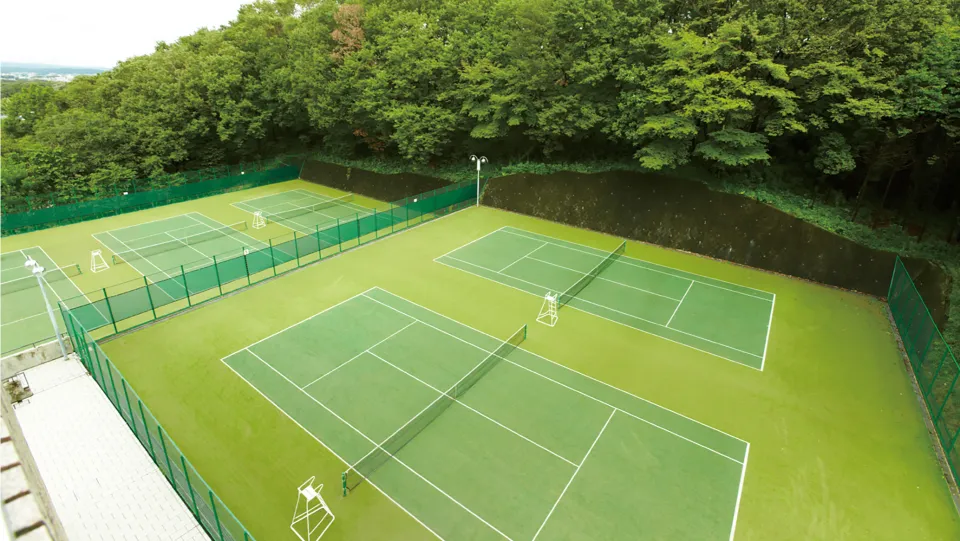 周囲が緑に囲まれた5面のテニスコート