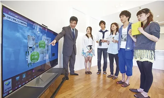 学生たちが画面を見ながら講師に教わっている様子