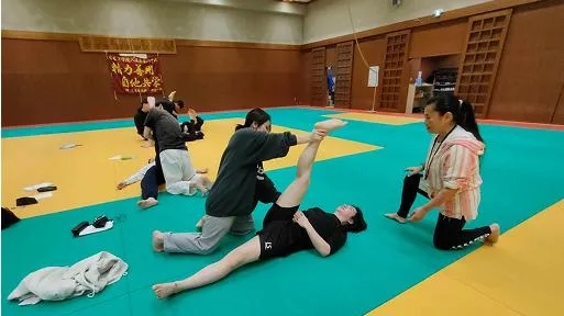 学生たちが横になっている人の脚を伸ばしてケアを行っている様子