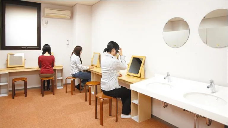3人の女性がパウダールームでメイク直しをしている様子