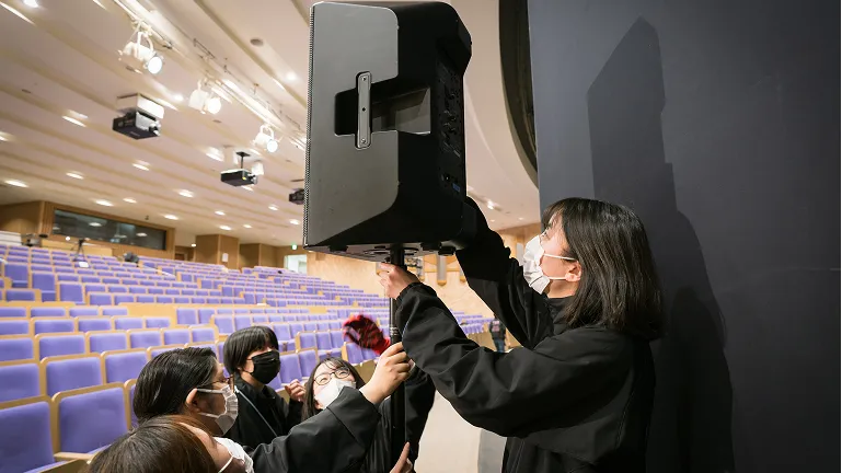 学生たちがスピーカーを配置している様子