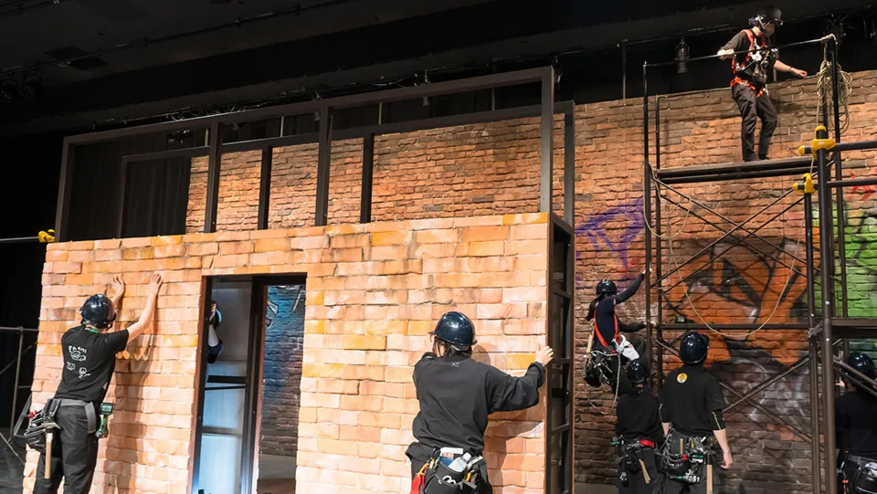 ヘルメットを被った学生たちが舞台を作っている様子