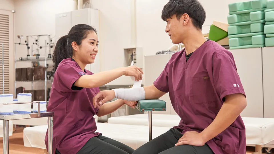 学生が腕に包帯を巻いている様子