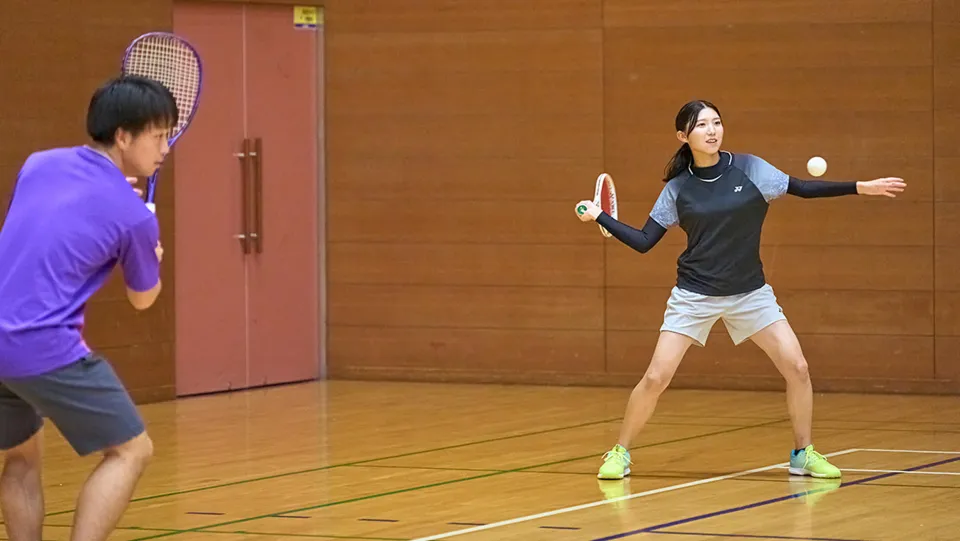 学生たちが室内でテニスをしている様子