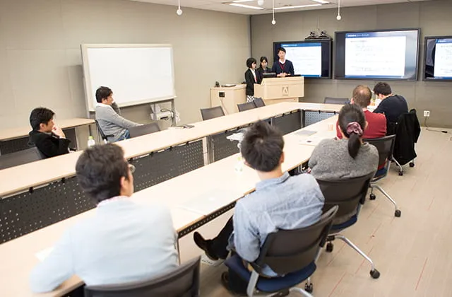 3枚の大型ディスプレイを使用して会議をしている様子