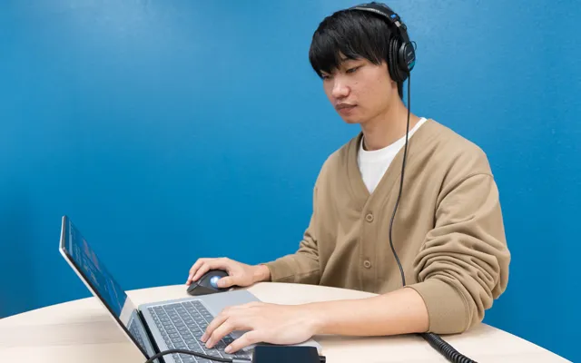 ヘッドホンを装着し制作作業を行うミュージックアーティスト科2年矢澤拓登さんの画像