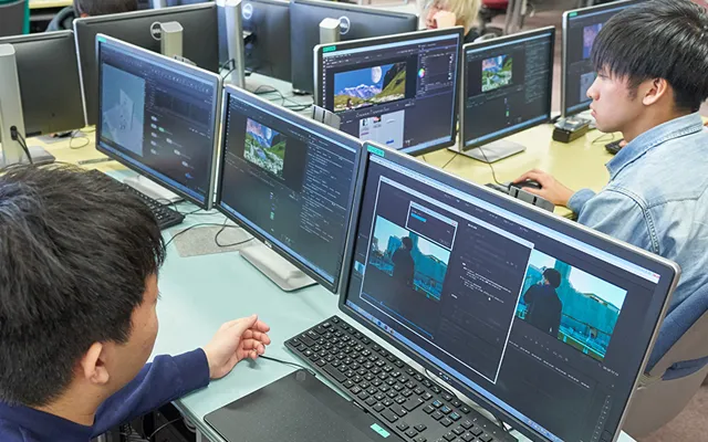 複数のディスプレイを使用して映像の編集作業を行う生徒