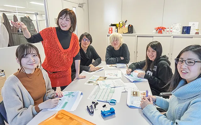 デーブルを囲んでグループ制作のミーティングを行っている生徒達の様子