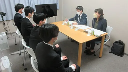 着席している学生たちがスタッフと対面して指導を受ける様子