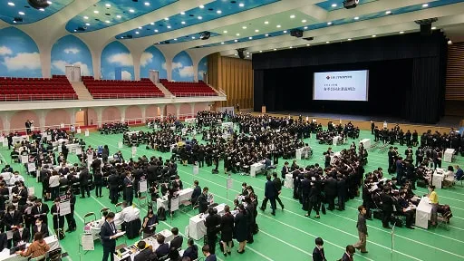 広い会場で多くの学生たちが各企業のブースに集まっている様子