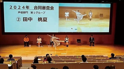 学生たちが広いステージ上でパフォーマンスの審査を受ける様子