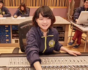 ミキサーテーブルの前に座りレコーディング中のイラスト