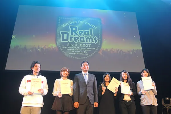 表彰された学生たちと理事長のステージ上での記念写真