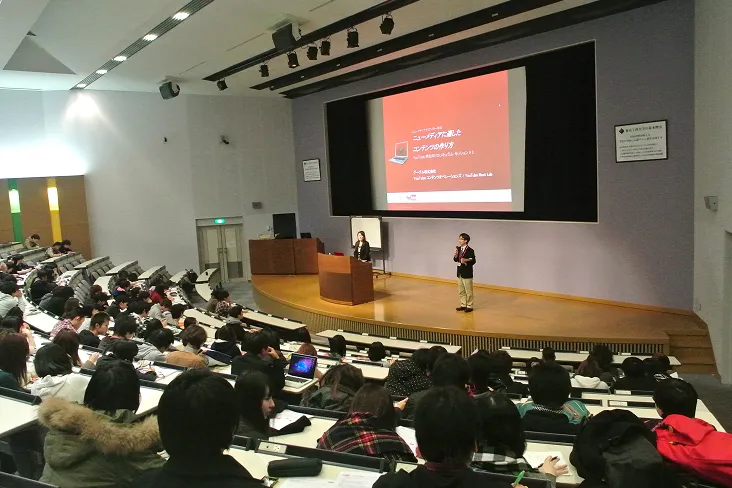 すり鉢状のホールでプロジェクター投影を使用した講義が行われている様子