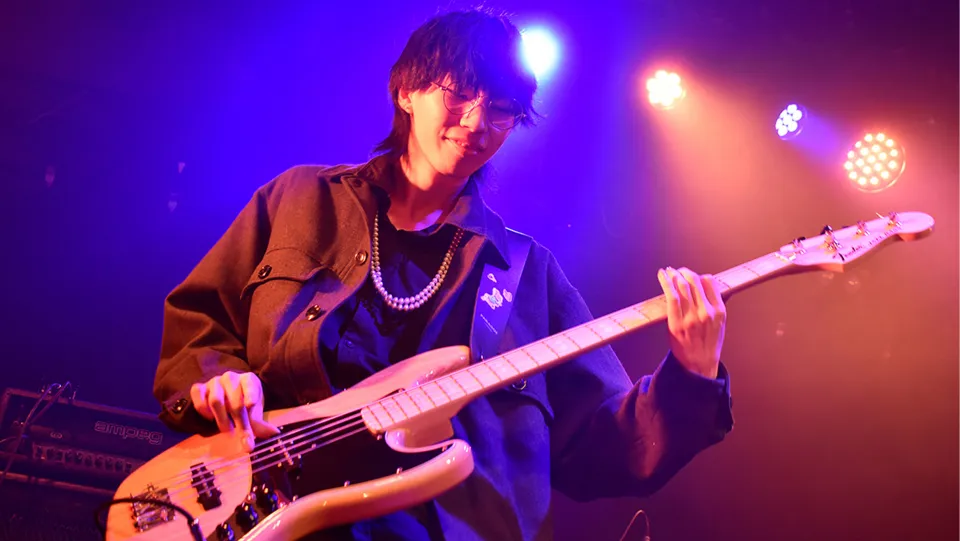 学生が照明に照らされたステージでライブパフォーマンスをする様子