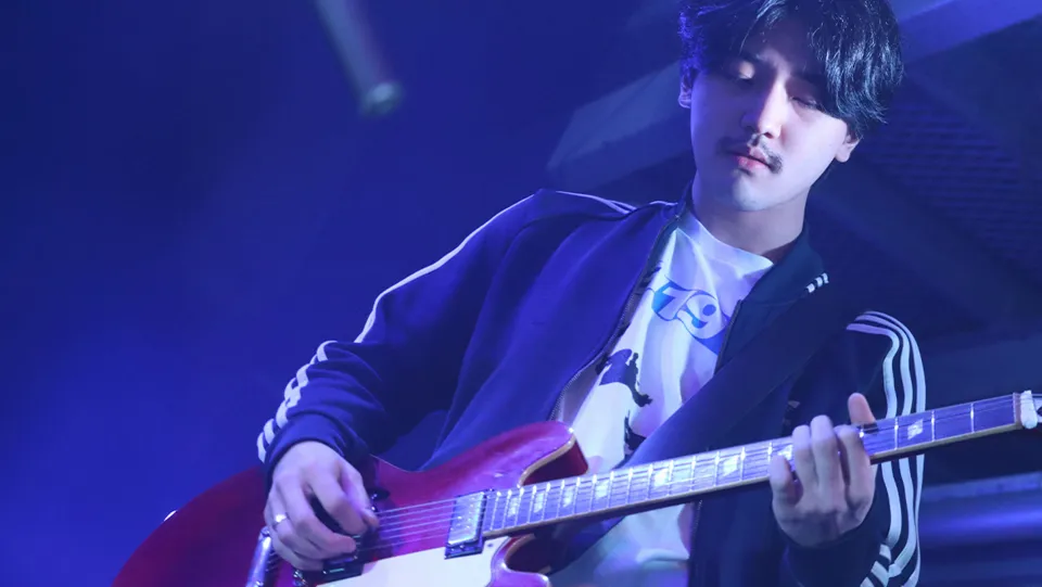 学生が照明に照らされたステージでライブパフォーマンスをする様子